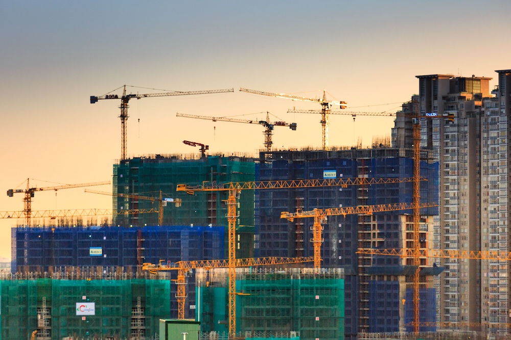 industrial-mro An apartment building construction site with cranes.