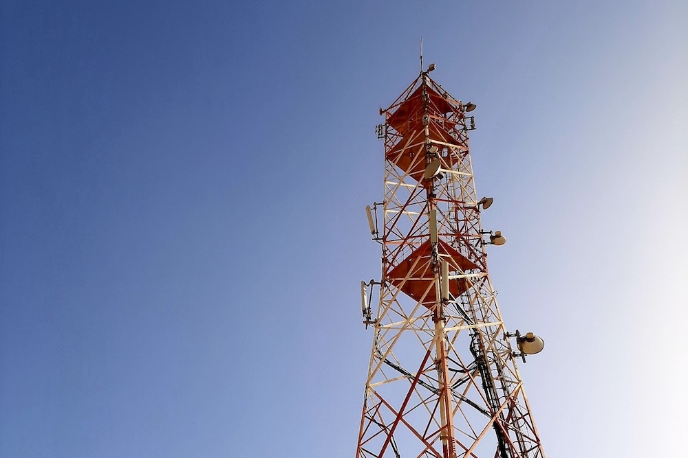 telecom-and-utilities A below view of a telecommunications tower against the sky.